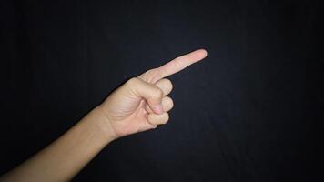 A hand showing a gesture pointing at something. Isolated on black background photo