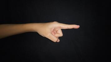 A hand showing a gesture pointing at something. Isolated on black background photo