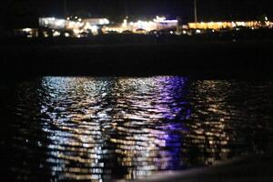 A view of the water at night with lights on photo