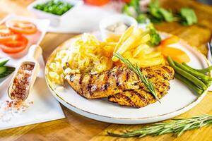 Fried Wiener schnitzel from veal topside with French fries as top view on a modern design plate with copy space photo