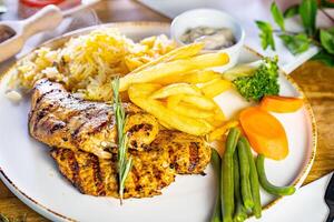 Fried Wiener schnitzel from veal topside with French fries as top view on a modern design plate with copy space photo