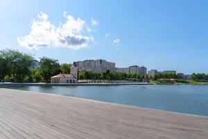 a wooden boardwalk along a lake with buildings in the background photo