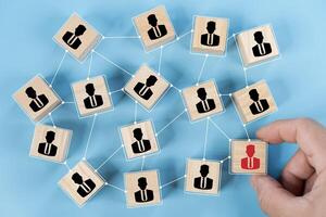 Hand touch red human icon on wooden block from team with line connection symbol for spread influence photo