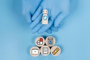 Doctor hand holding wooden block with smiling face with healthcare-related icons, such as a cross photo