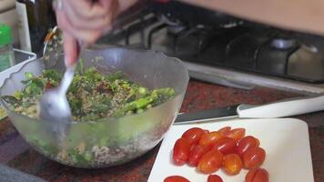 Hands mixing fresh asparagus salad and adding cherry tomatoes to it video