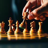 Close-up of hand moving chess piece on a board. photo