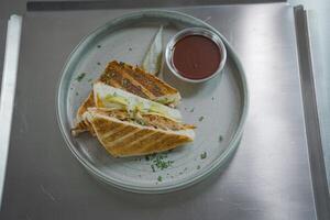 Grilled sandwich with vegetables, ham and cheese on a table. Top view. Fast food. Flat lay concept. photo