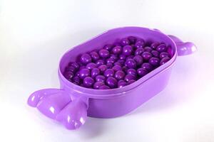 purple chocolate candy ball isolated on white photo
