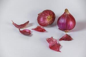 two shallots and their skin crumbs isolated on white photo
