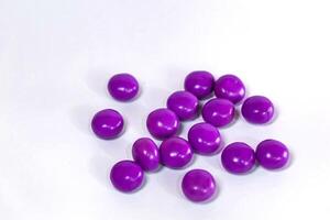 purple chocolate candy ball isolated on white photo