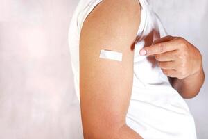 hand pointing to arm with injection marks photo