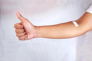 hand shows arm with injection marks and giving thumb up photo