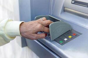 Person using atm keypad for secure banking transaction with finger on green button photo