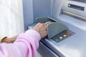 Person using an atm close-up of hand entering pin on secure banking terminal photo
