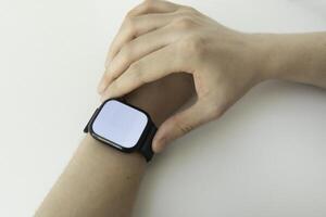 Young man using electronic smartwatch on his hand. Wearables with digital touchscreen and mobile app technology. Person using wristwatch for business and work. Device with touch interface. photo