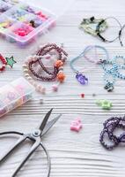 Crafting colorful jewelry with beads and charms on a wooden table during a creative afternoon photo
