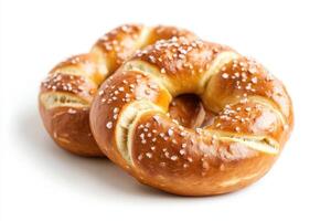 Two freshly baked pretzels sprinkled with coarse salt on a white background. photo