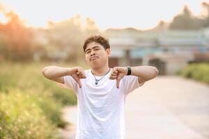a man standing with a thumbs down. The man acted like someone was underestimating something. set in nature on a sunny afternoon. photo