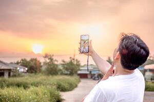 a man who is taking photos of himself and nature in various styles. the man has his back to the camera. set on a sunny afternoon in nature.