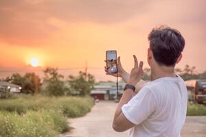 a man who is taking photos of himself and nature in various styles. the man has his back to the camera. set on a sunny afternoon in nature.