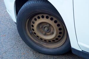 Rotated front wheel of a car without a cap with a rusty rim photo