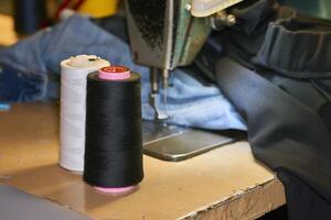 A spool of black white threads on an old sewing machine in a tailor's workshop photo