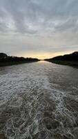 Flowing stream of dirty water in the river, river filled with dirty water after flood. Oder River, Poland photo