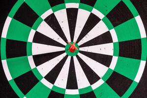 Dart arrow in bullseye target on dartboard photo