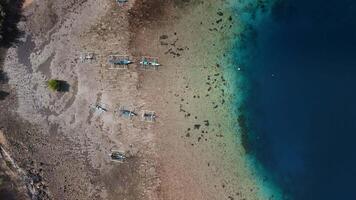 Coastline landscape in West Bali with blue ocean and boats on low tide, Aerial view, top down video