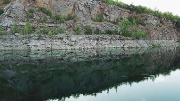 4K aerial . Smooth takeoff above the water surface. Abandoned quarry, filled with turquoise water. video