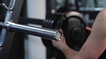 Young girl in the training in the gym. Preparation to do exercises with weights. Close-up. Professional sports equipment video
