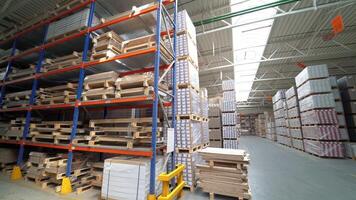 Shelves of warehouse are filled with parquet. Stock of woodworking factory. Camera motion to around video