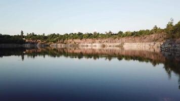 Aerial view of a beautiful lake at the site of a former quarry. Beautiful landscapes of wild nature with a lake with high banks of stone. 4k . video