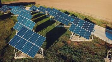 Visão do dois linhas do solar painéis em a fundo do verde grama. plantar para a Produção do solar painéis. aéreo visualizar. ecologia. video