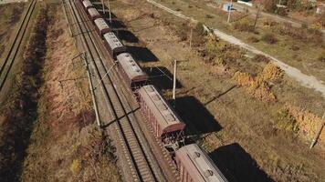 freight train is passing a highway. Aerial view of the freight train with wagons video