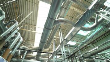 Pipes of the ventilation system are located on the ceiling of plant with the production of parquet. Camera motion to left video