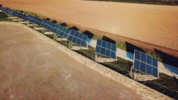 Visão do uma linha do solar painéis dentro a verão dentro a campo. aéreo visualizar. ecologia. video