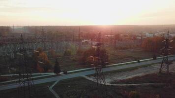 view of the structure of high-voltage lines outside the city at sunset. Camera motion back. Aerial view video