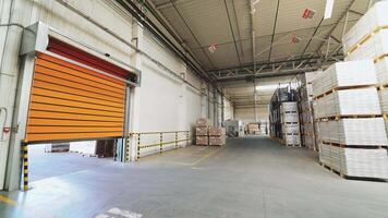 Orange rolling door of the warehouse is closing. Rolettes work with the help of automation. Motion of rolling door to down video