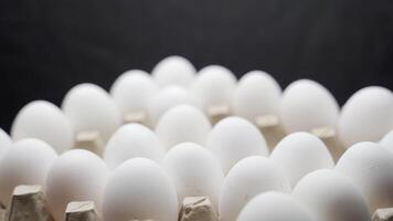 Hand puts eggs in a box. Eggs are stacked in a tray. video