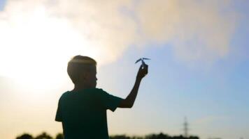 Kid Playing With Flying Paper Plane. Cute boy throwing a paper airplane into the sky in grass video