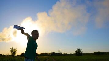 Kid spend time in grass and playing with paper plane near air pollution video