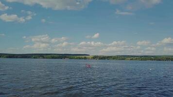 two men are rowing oars through the waves in the river in a kayak to the bank. Active weekend. Wonderful landscape video