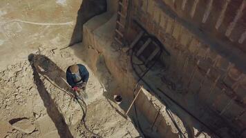 a man is drilling stones with using power tool in a sand quarry. Camera motion up video