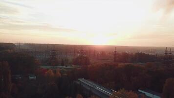 view of the site with high-voltage lines on the background of the road and trees at sunset. Camera motion forward. Aerial view video