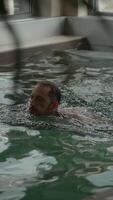 A person gracefully swimming in an indoor pool that features a serene and relaxing atmosphere video