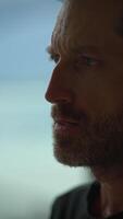 A contemplative man is seen in profile against a natural background, evoking a serene atmosphere video