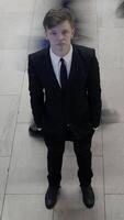 A Young Man Dressed in Formal Elegance Surrounded by a Busy and Crowded Urban Scene video