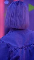 A solitary figure gazes up in a vibrant neon atmosphere full of intrigue and fascination video