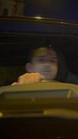 A nighttime driver navigating through an illuminated urban landscape, filled with atmosphere video